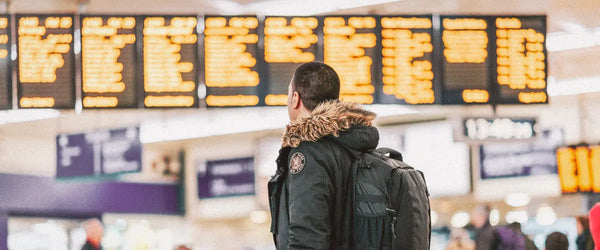 A traveler looking at airline departure boards