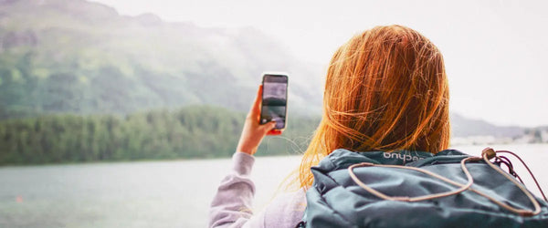 A female traveler taking a photo with her smartphone