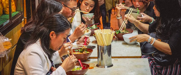 People eating food from a street food stall in Hong Kong