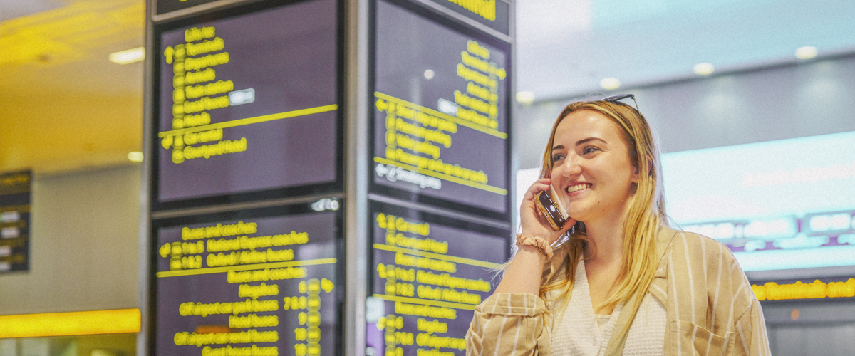 A woman using her smartphone in an airport lounge