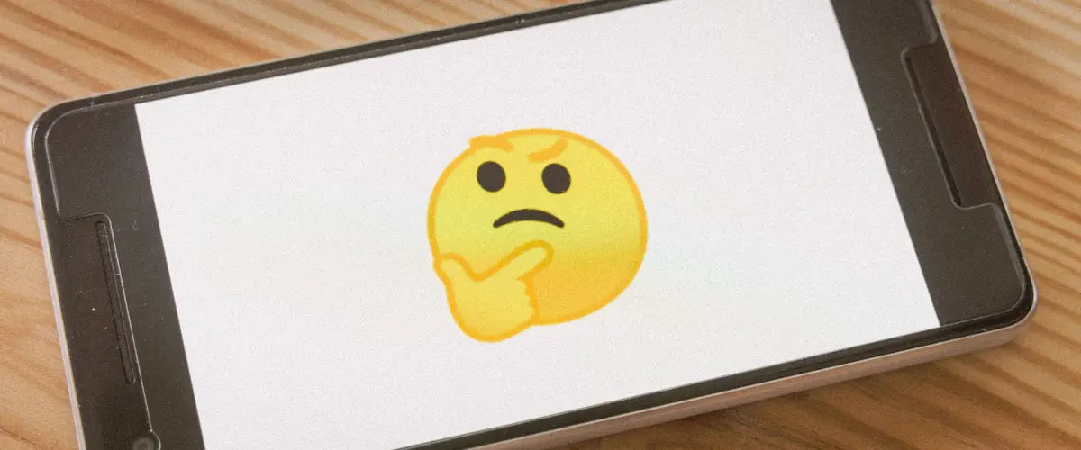A smartphone showing the thinking face emoji on a white background