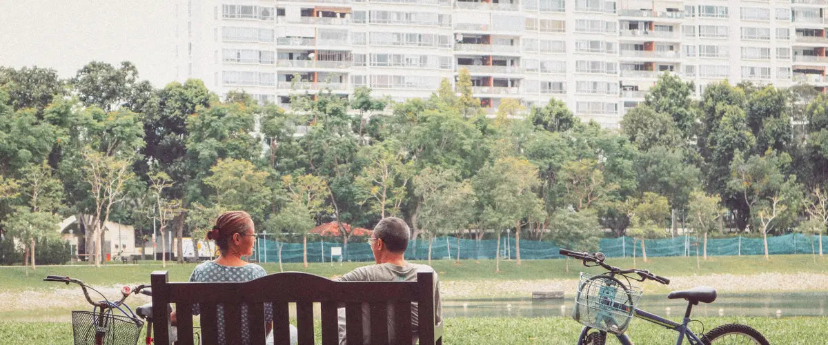 A man and a woman sitting on a bench in a park in Singapore