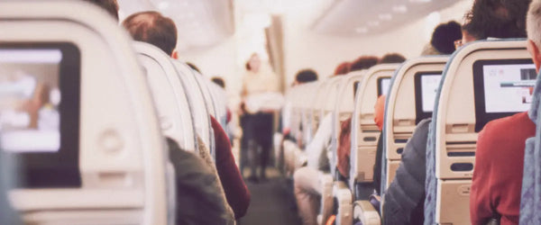 View from an airplane seat, looking behind other passengers' seats