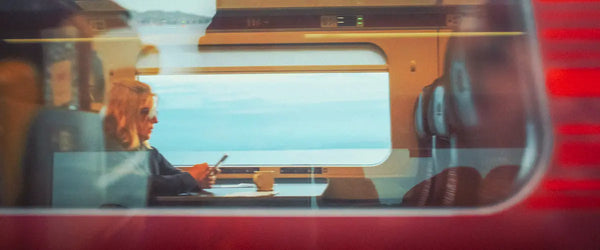 Someone sat using a smartphone while traveling via train