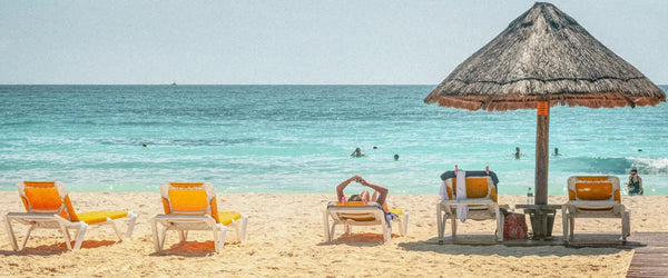 Lounge chairs facing the sea on a beach in Cancún, Mexico