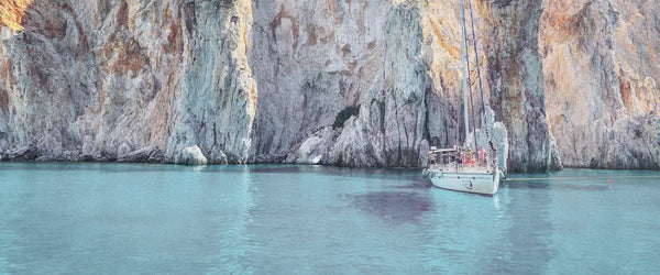 A sailboat near cliffs in Santorini, Greece