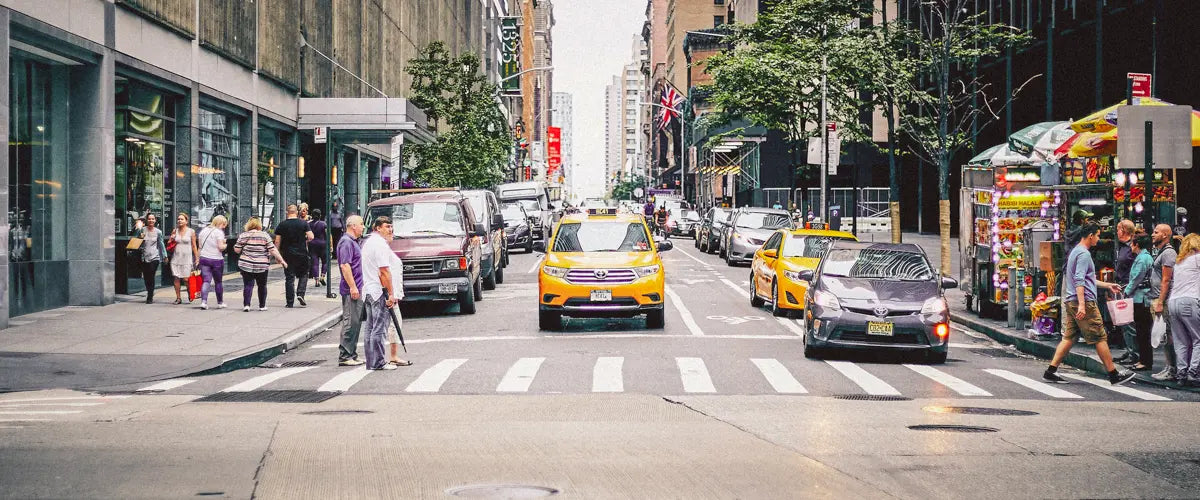A yellow taxi driving down a street in Manhattan, New York City, US