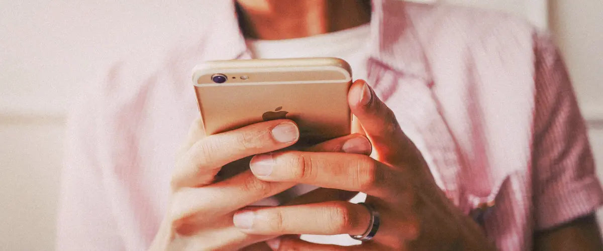 A close-up of someone using a gold iPhone