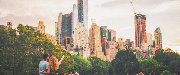 A couple pointing up at the New York City skyline