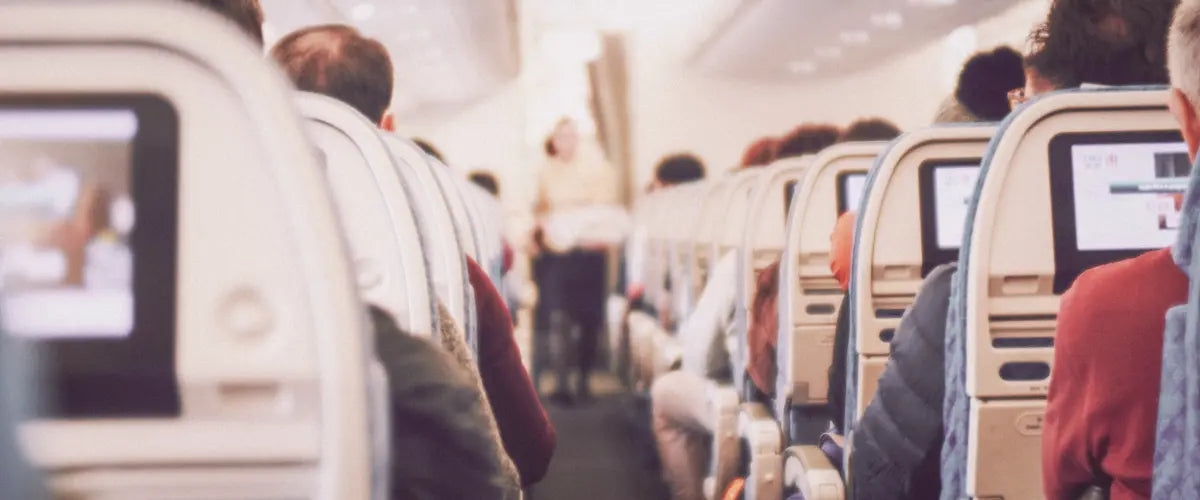 View from an airplane seat, looking behind other passengers' seats
