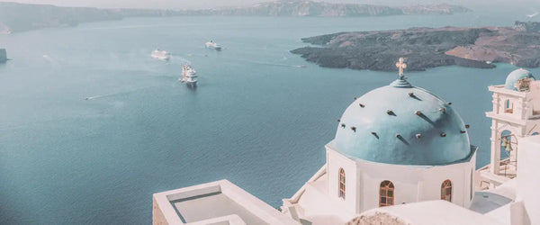 A church with a blue dome overlooking the sea in Santorini, Greece