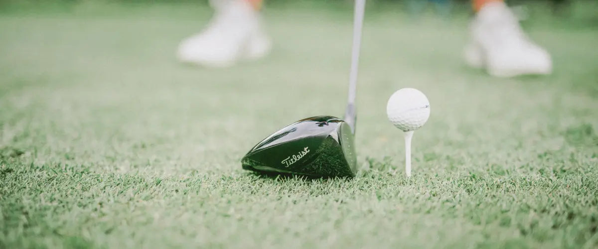 Close-up of a golfer's club about to tee off