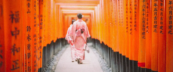 Someone walking through torii gates at the Fushimi Inari Shrine in Kyoto, Japan